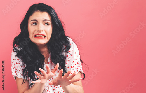Disgusted face expression with young woman on a solid background