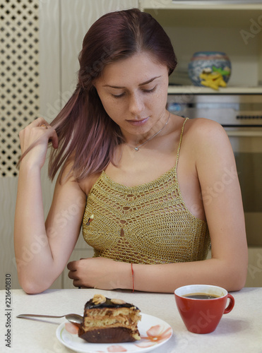 The girl is drink a coffee and seat in the table