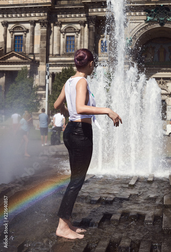 wet girl in the fountain with a rainbow