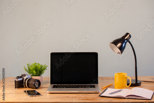 workspace with laptop computer, office supplies houseplant, vintagr camera at home or studio office. photo