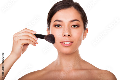 Beautiful woman with makeup brush . Face beauty
