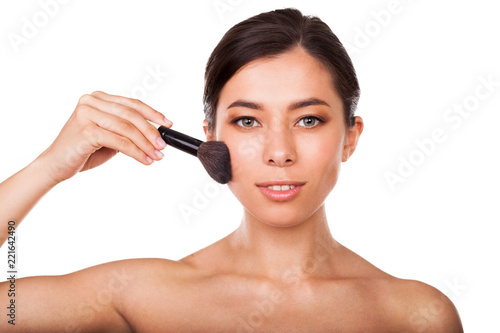 Beautiful woman with makeup brush . Face beauty