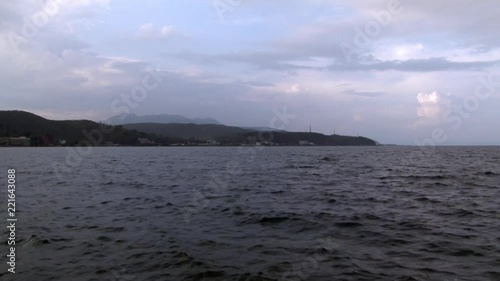 Fuxian Lake in Yunnan Province China. Unique mountain lake in East Asia. Landscape on background of sky with gray clouds and fog. Silence and tranquility of nature. photo