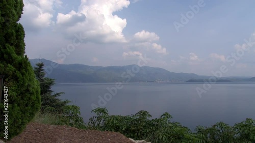 Plants on coast of Fuxian Lake on background landscape of mountain and fog. Unique mountain lake in Yunnan Province China. Silence and tranquility nature of East Asia. photo