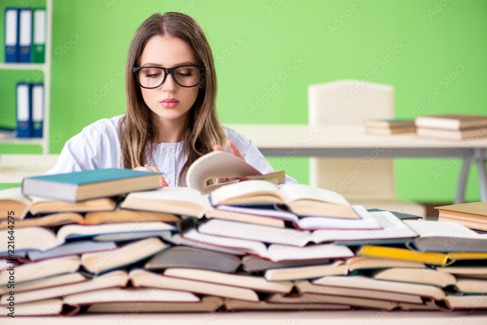 Young female student preparing for exams with many books Young female student preparing for exams with many books