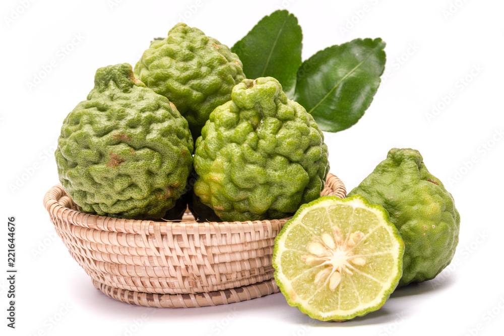 The kaffir lime leaves in the basket on a white background. The kaffir lime leaves in the basket on a white background.
