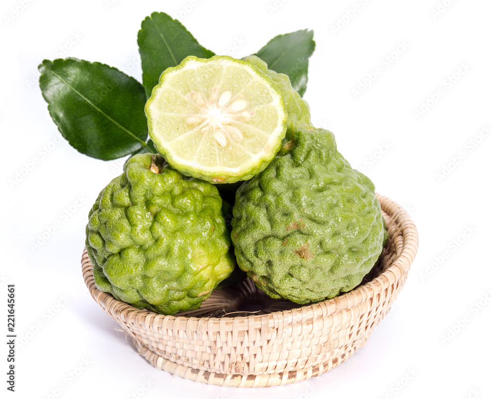 The kaffir lime leaves in the basket on a white background. The kaffir lime leaves in the basket on a white background.