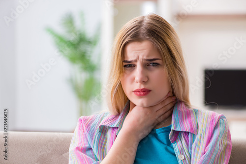 Young woman suffering from sore throat pain