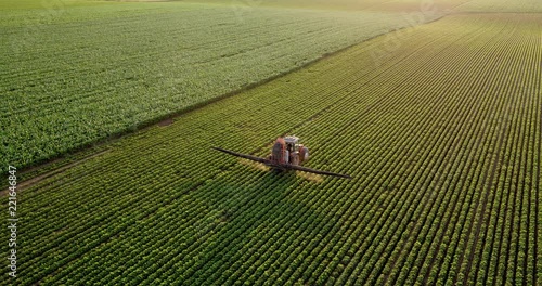 Aerial drone shot of a farmer spraying soybean fields