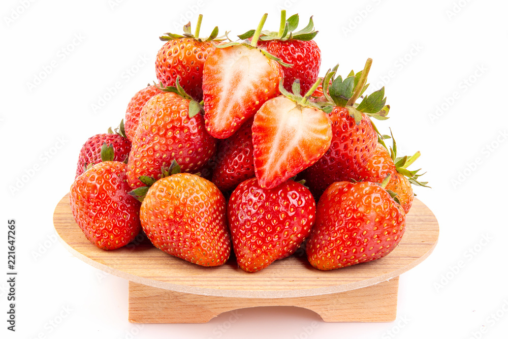 Heap of fresh strawberries in ceramic bowl  on the wooden tray.