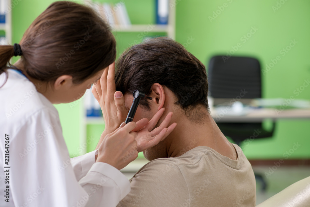 Female doctor checking patient's ear during medical examination Female doctor checking patient's ear during medical examination