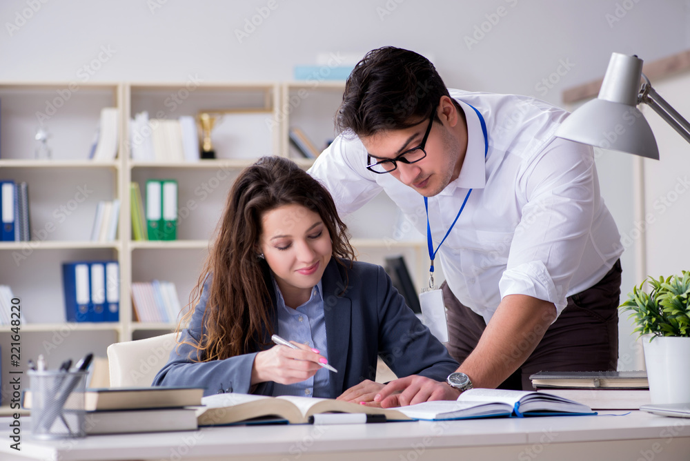 Teacher explaining to student at lecture Teacher explaining to student at lecture