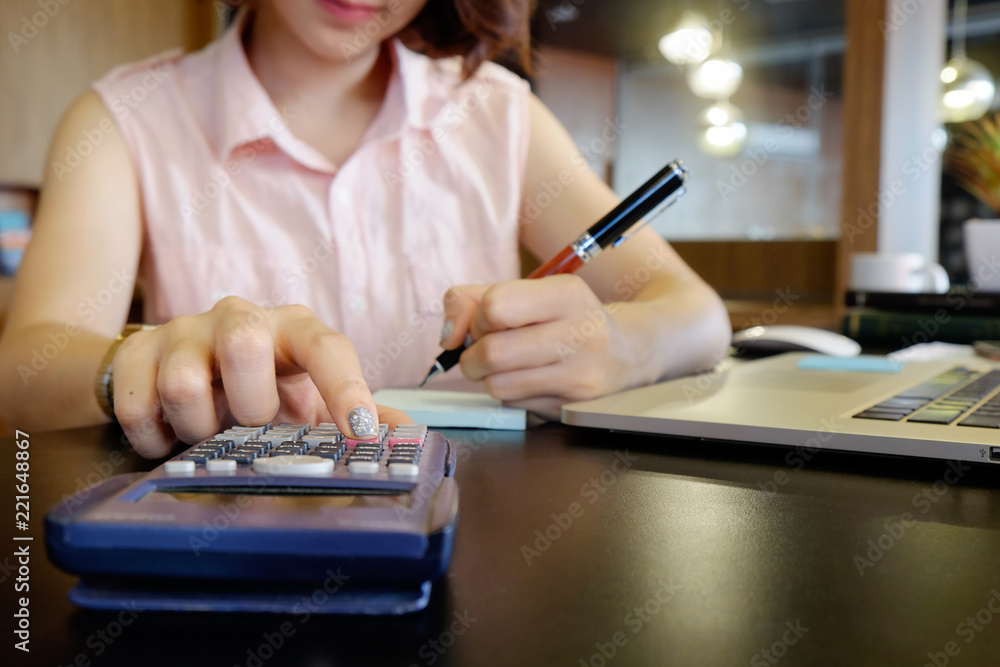 Fototapeta premium Business finance concept, cropped shot of female calculate of financial data with calculator.