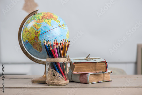 School background, books, globe and color pencils are on the desk photo