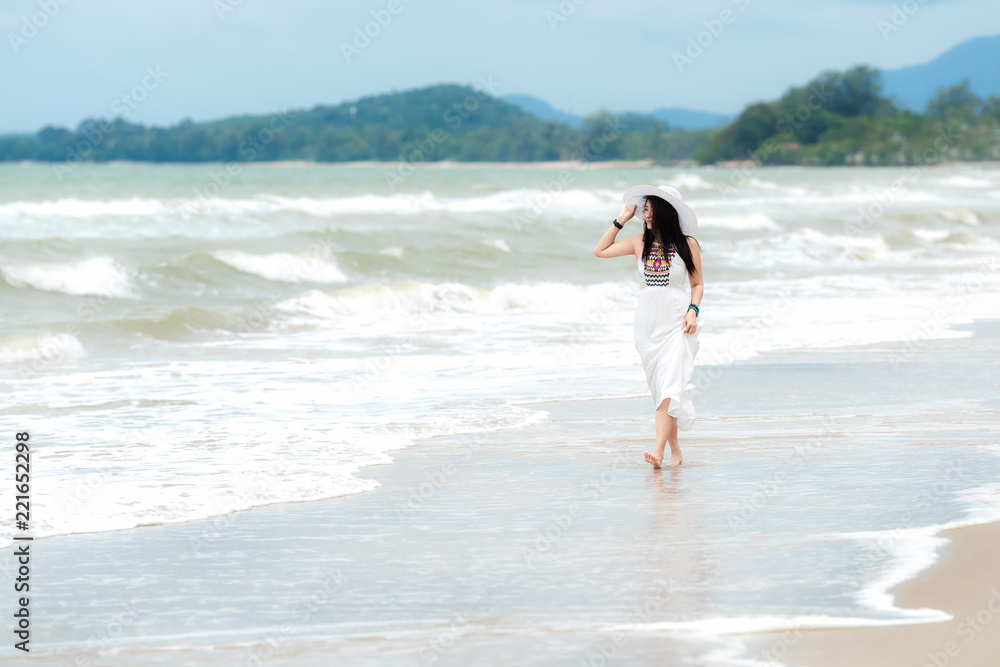 Fototapeta premium Summer Vacations. Lifestyle women relaxing and enjoying swing on the sand beach, fashion stunning women with white dress on the tropical island so happy and luxury in holiday summer. 