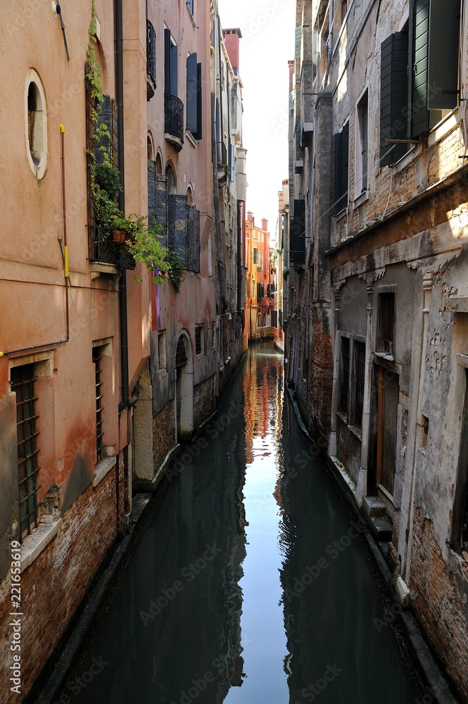 Canale navigabile nella città turistica di Venezia con abitazioni e riflesso nell'acqua