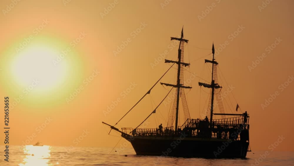 Beautiful sunset. The ship sails the waves during sunset. Sea walk on a sea ship. Silhouette of the ship at sunset. Beautiful sunset. The ship sails the waves during sunset. Sea walk on a sea ship. Silhouette of the ship at sunset.