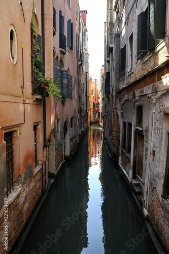 Canale navigabile nella città turistica di Venezia con abitazioni e riflesso nell'acqua © kromatika