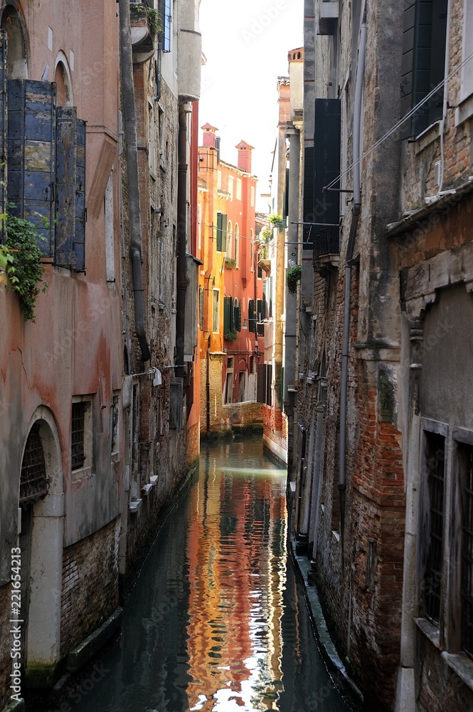 Canale navigabile nella città turistica di Venezia con abitazioni e riflesso nell'acqua