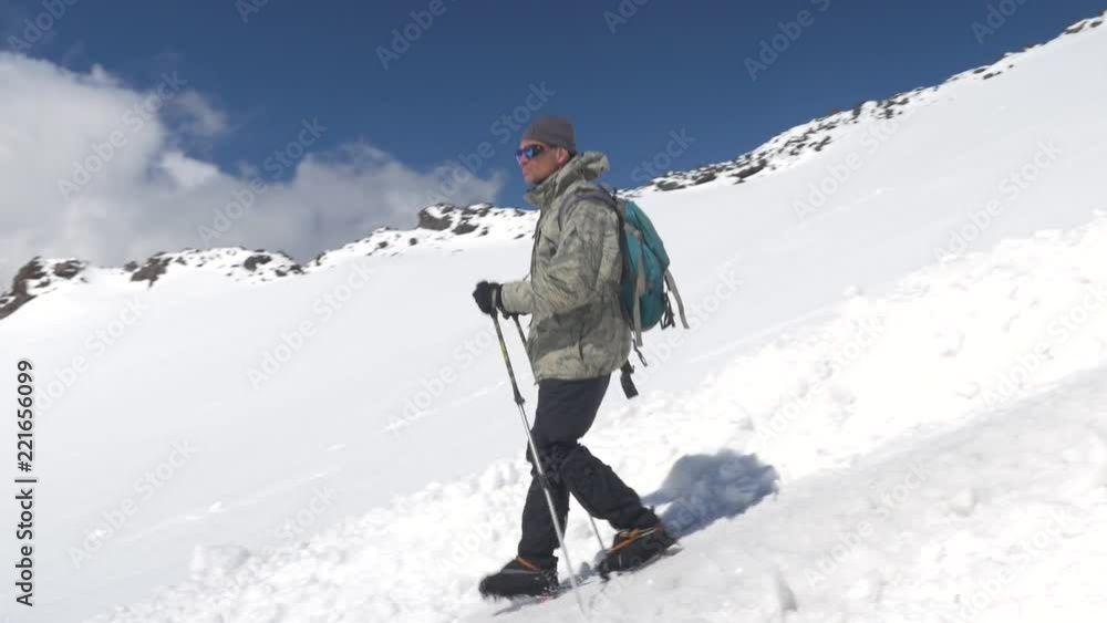 A man climber, descends the snow-covered slope down to the base camp. Mount Elbrus, the Caucasus Mountains. A man climber, descends the snow-covered slope down to the base camp. Mount Elbrus, the Caucasus Mountains.