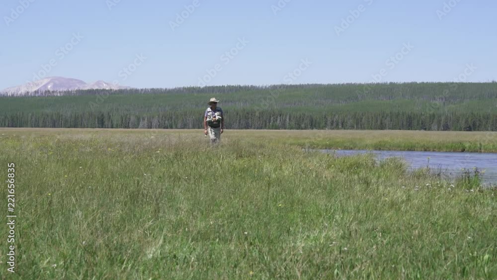 Fly-fisherman walking by the river of Montana state Fly-fisherman walking by the river of Montana state