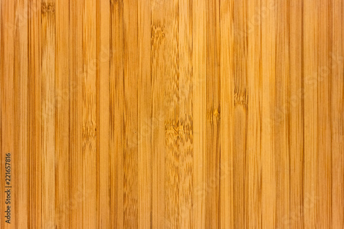 Texture of a board with a vertical pattern of bamboo fibers, soft focus