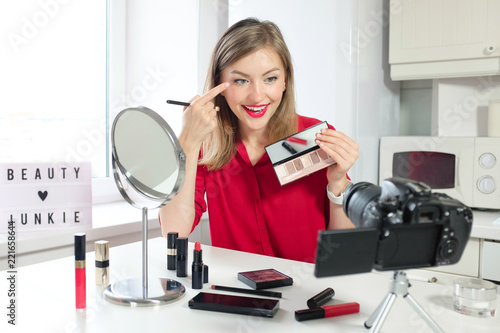 Cheerful female vlogger showing palette while recording video and giving advice for popular blog. Famous blogger, beauty junkie concept