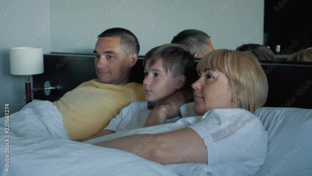 Happy family watching television together at home and laughing with pleasure together. Happy family watching television together at home and laughing with pleasure together.