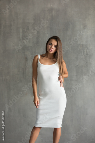 Beautiful sexy woman in white skin-tight dress.