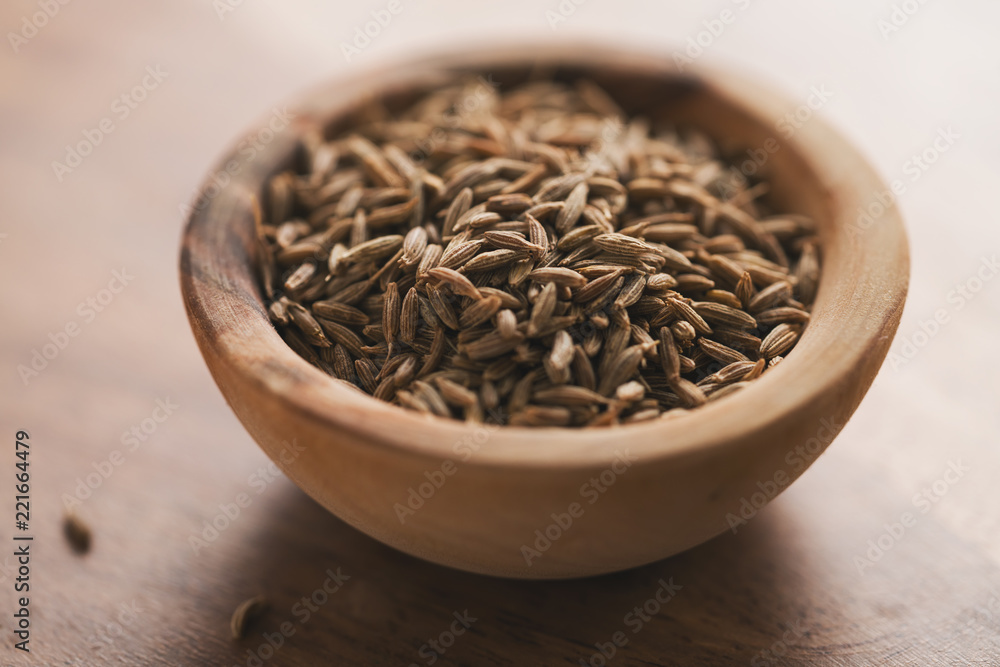 cumin zira seeds in wood bowl on table cumin zira seeds in wood bowl on table