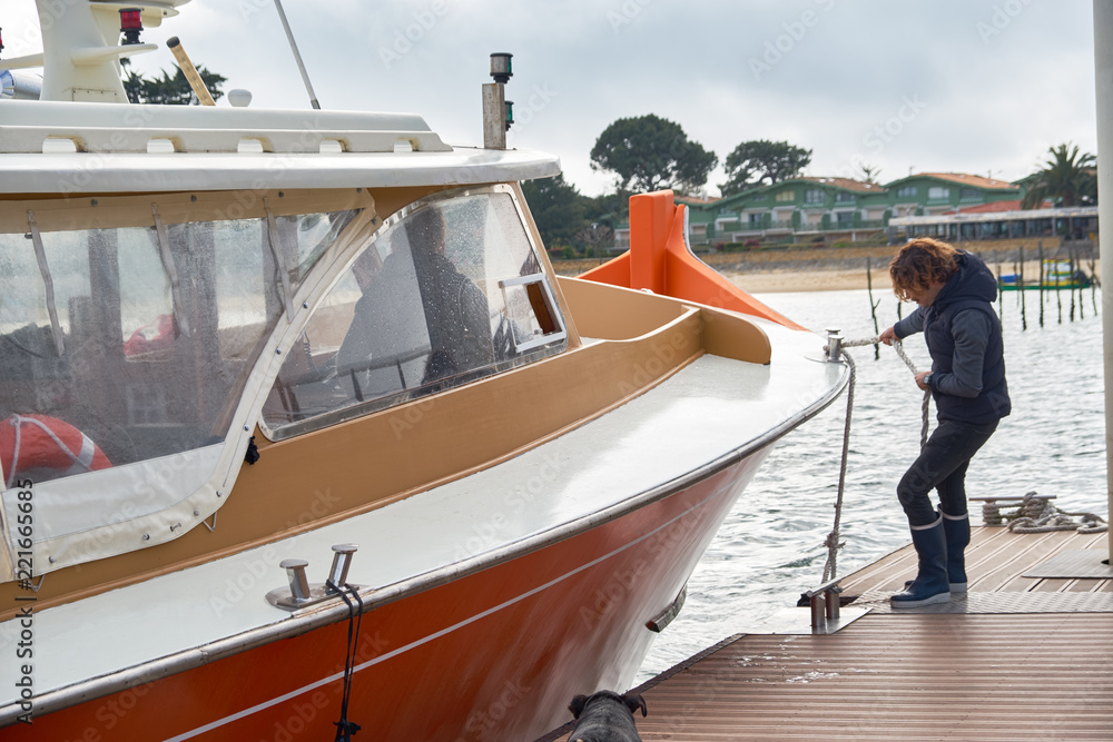 Obraz premium Young man tightens the ropes on the sails of the yacht. Sailing and recreation