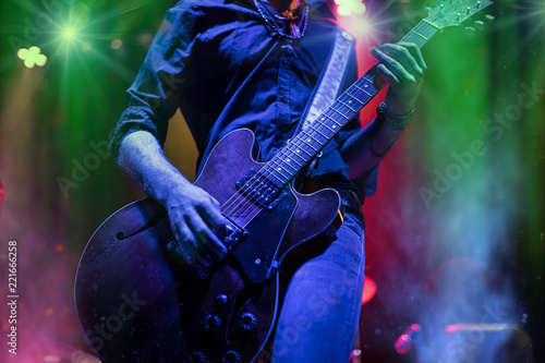 A rocker is playing guitar on stage.