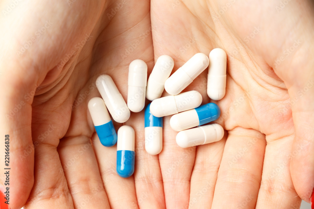 Colorful pills and tablets in the woman hands on white background. Top view. Flat lay. Copy space. Close up. Medicine concept Colorful pills and tablets in the woman hands on white background. Top view. Flat lay. Copy space. Close up. Medicine concept