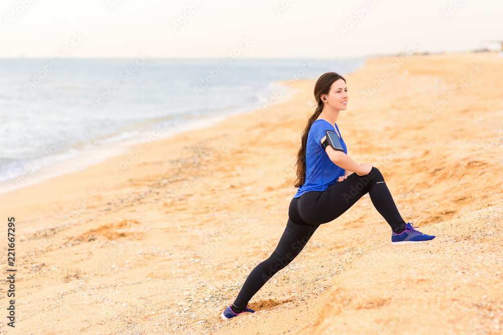 woman doing stretch exercises on the sea beach woman doing stretch exercises on the sea beach