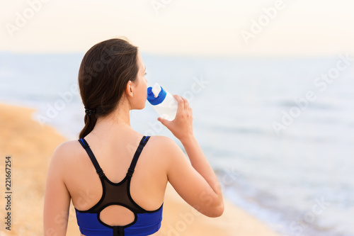 woman drinks water on the sea beach