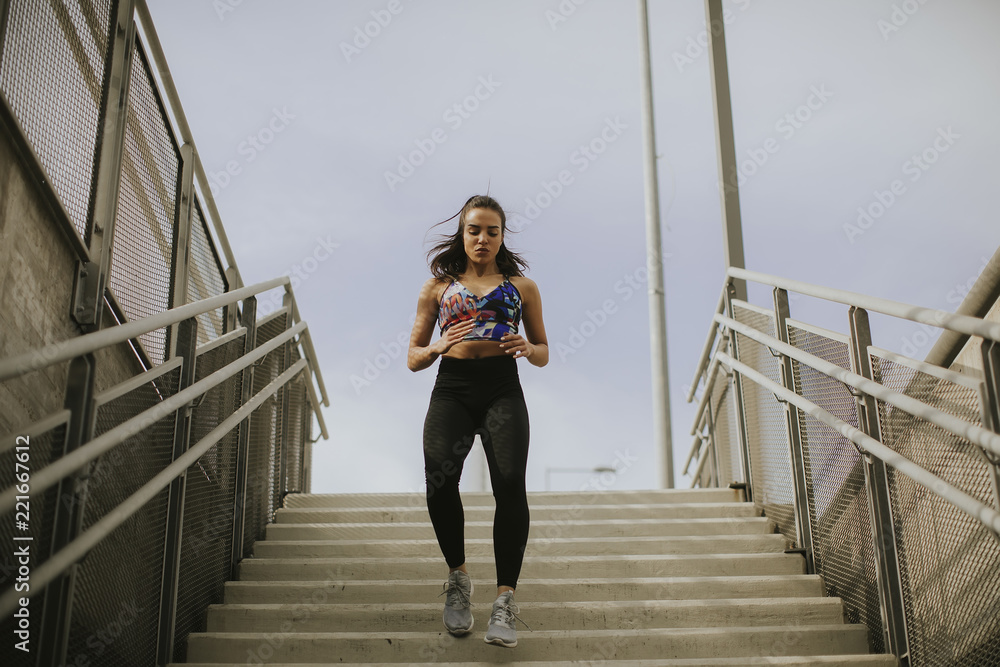 Young woman running alone down the stairs Young woman running alone down the stairs