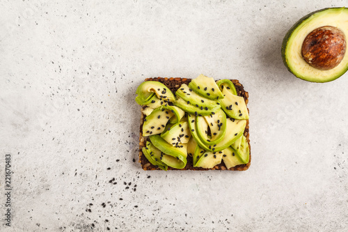 Avocado toast on a healthy sesame bread with sesame seeds, top view. Healthy vegan food concept.