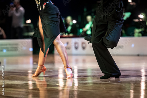 Beautiful womanish and masculine legs in active ballroom dance, indoors