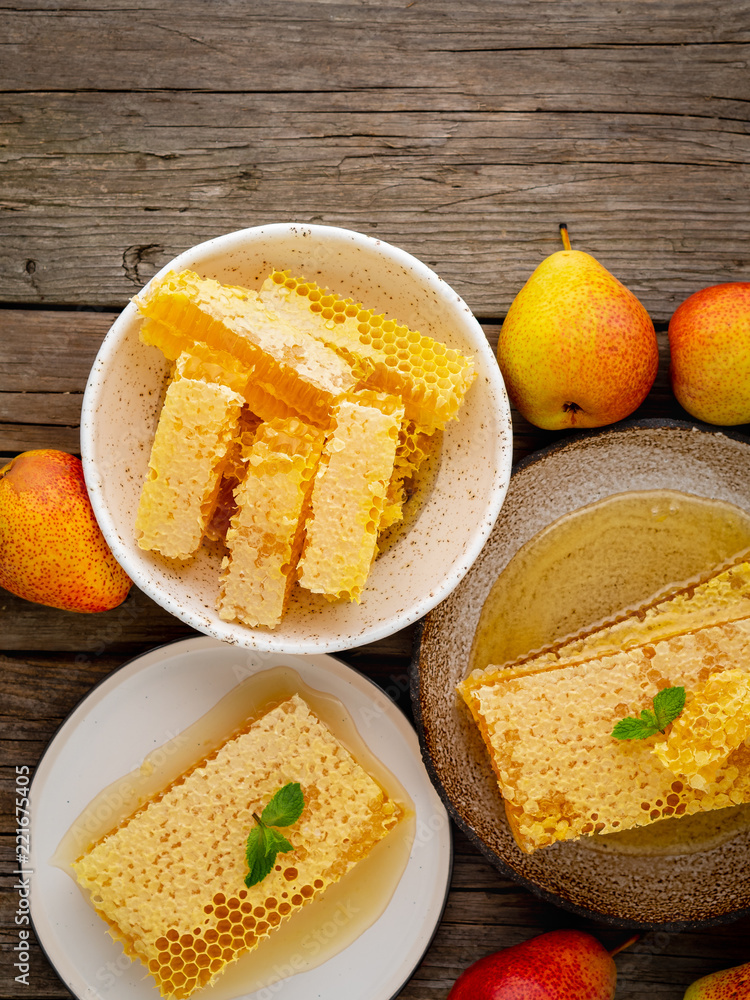 honey in honeycomb, close-up, on brown ceramic plate, on old gray wooden rustic table, top view, vertical, copy space honey in honeycomb, close-up, on brown ceramic plate, on old gray wooden rustic table, top view, vertical, copy space