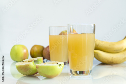 two glasses of apple juice, juice in glasses, fresh apples on a white background