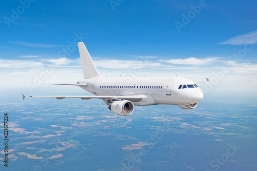 Samolot pasażerski leci na wysokości nad chmurami i błękitne niebo.