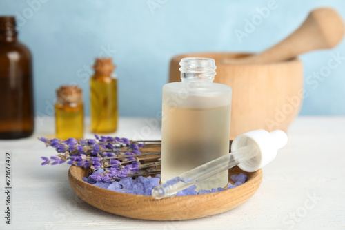 Fototapeta Naklejka Na Ścianę i Meble -  Bottle with aromatic lavender oil on wooden table