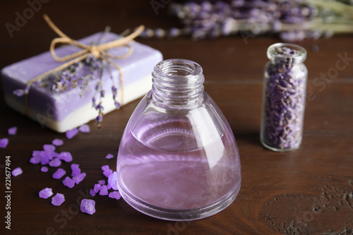 Fototapeta Naklejka Na Ścianę i Meble -  Bottle with aromatic lavender oil on wooden table