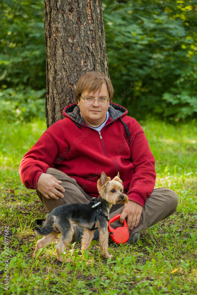 A fat man and a small dog on a walk. Yorkshire Terrier A fat man and a small dog on a walk. Yorkshire Terrier