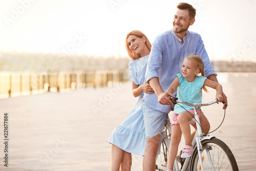 Happy family riding bicycle outdoors on summer day