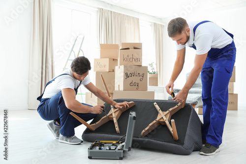 Male movers assembling sofa in new house