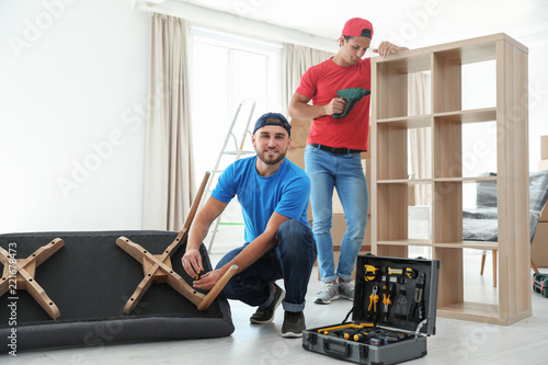 Εκτύπωση καμβά Male movers assembling furniture in new house