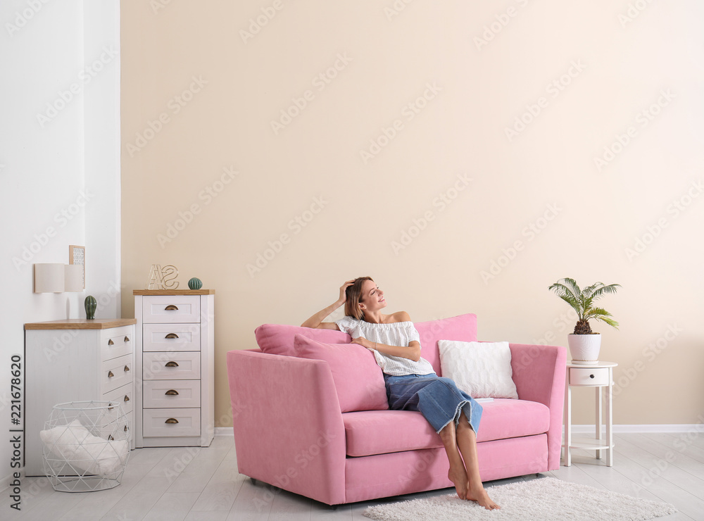 Happy young woman sitting under air conditioner at home Happy young woman sitting under air conditioner at home