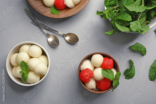 Flat lay composition with mint, melon and watermelon balls on grey background