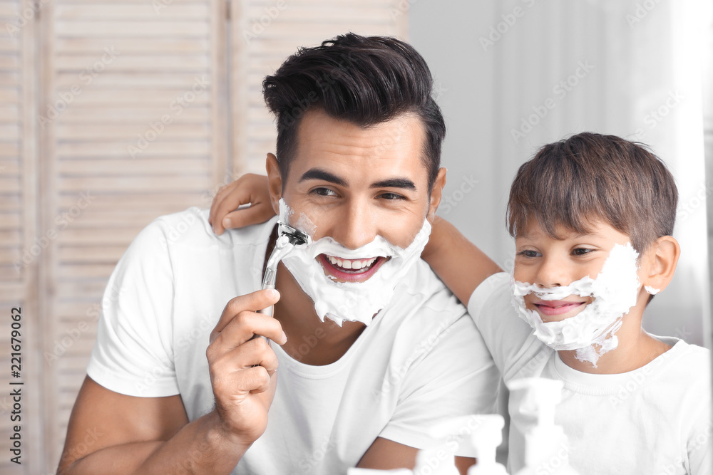 Father and son having fun while shaving in bathroom